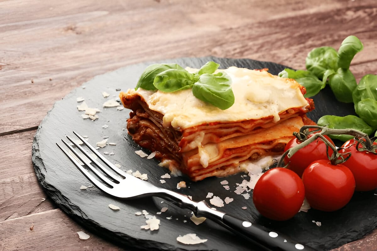 Lasagnes aux légumes gratinées avec basilic frais Part de lasagnes aux légumes avec fromage fondu et basilic frais