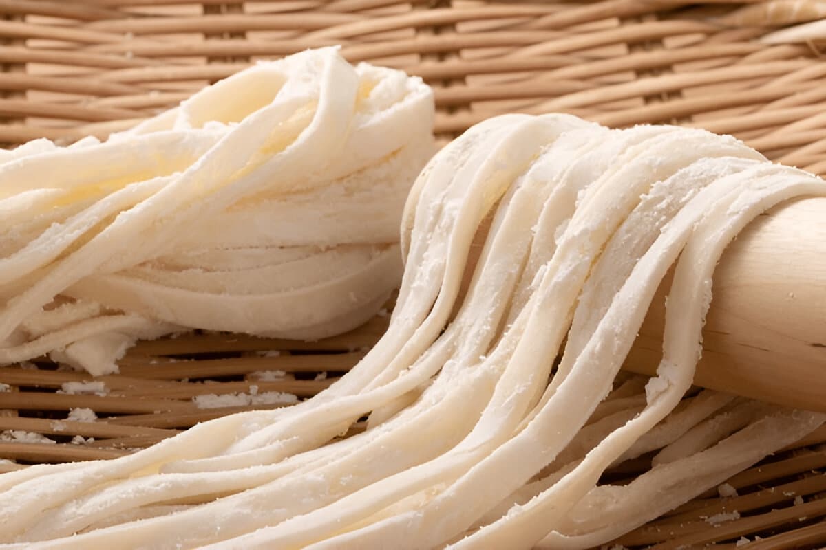 Nouilles udon japonaises servies nature Nouilles udon cuites servies dans un bol noir avec des baguettes