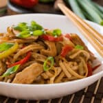 Nouilles udon sautées au poulet, poivrons et oignons nouveaux