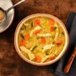 Soupe vermicelle aux légumes dans une assiette blanche émaillée