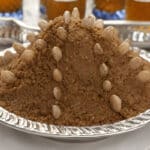 Monticule de sellou décoré d’amandes entières sur un plat marocain