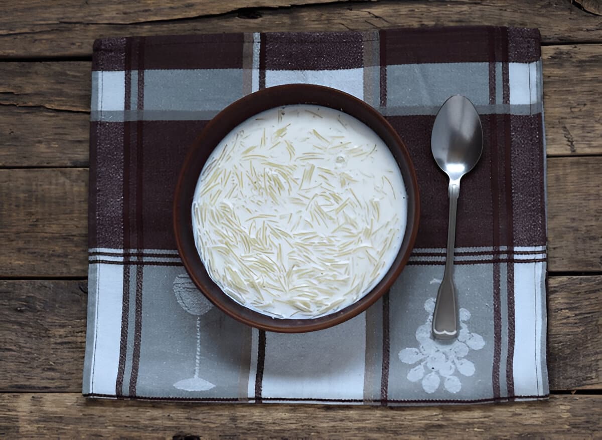 Soupe au lait et vermicelles traditionnelle servie chaude Bol de soupe au lait avec vermicelles sur une nappe à carreaux