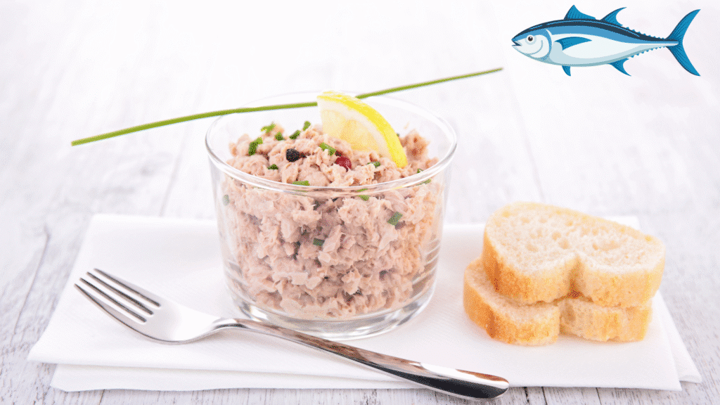 Verrine de tartinade de thon garnie de citron et ciboulette, accompagnée de tranches de baguette.