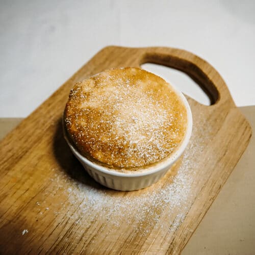 Soufflé nuage doré dans un ramequin sur planche en bois