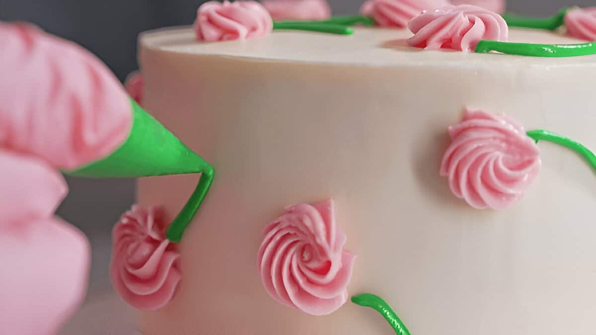 Gâteau fleuri en cours de décoration Décoration d’un bento cake avec des fleurs en crème