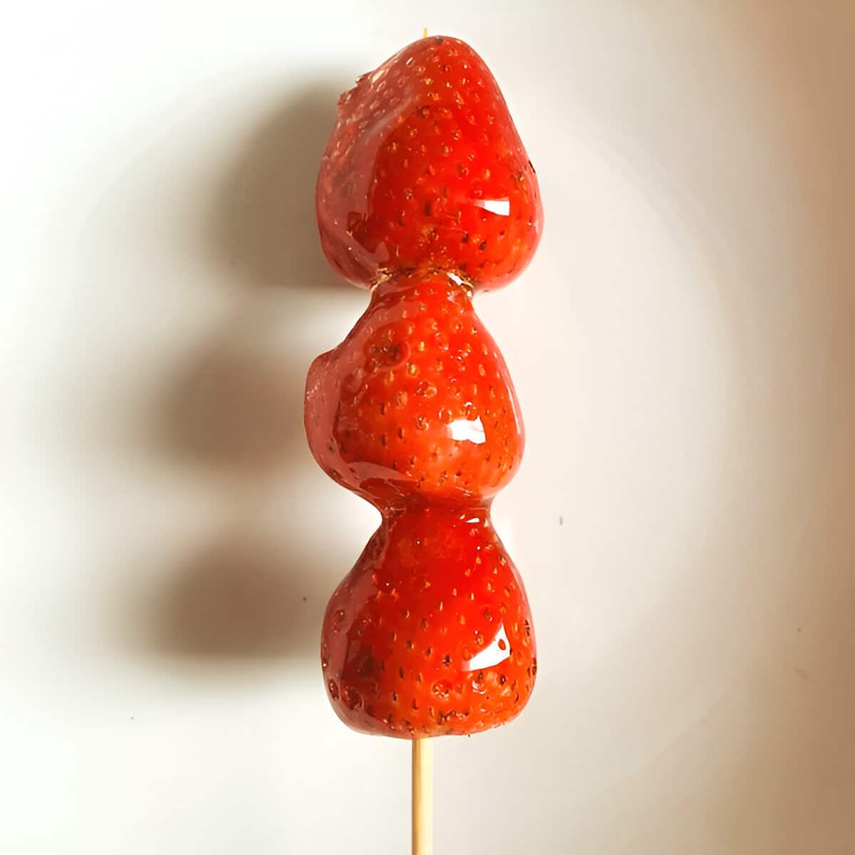 Tanghulu fait maison avec trois fraises brillantes Brochette de tanghulu aux fraises
