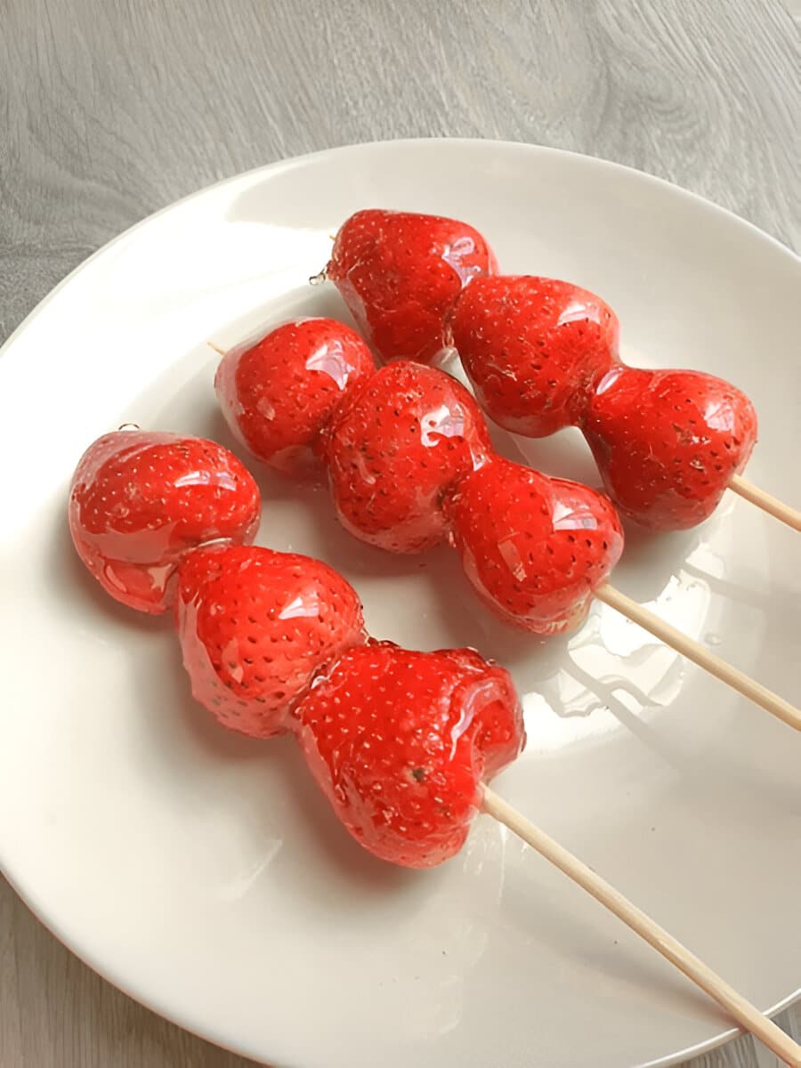 Tanghulu fait maison avec trois fraises brillantes Assiette de tanghulu aux fraises