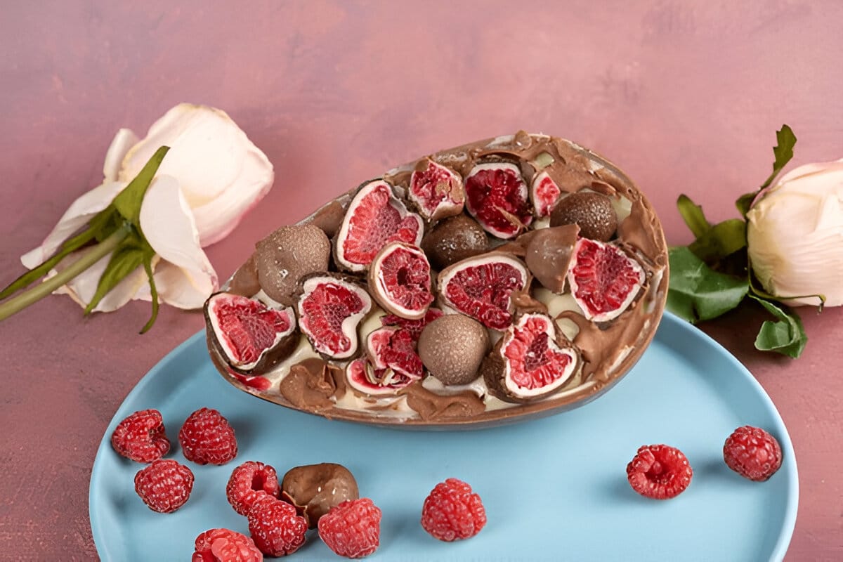 Dessert en forme d’œuf en chocolat rempli de framboises et truffes.