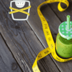 Verre de jus detox citron gingembre sur une table en bois