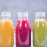 Verre de jus detox citron gingembre sur fond clair