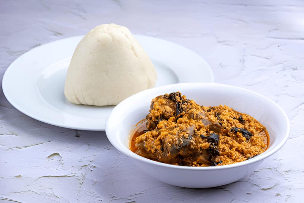 Foufou Un plat nigérian de fufu servi avec une soupe Egusi garnie de viande.