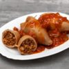Encornets crus farcis, disposés dans une assiette blanche.