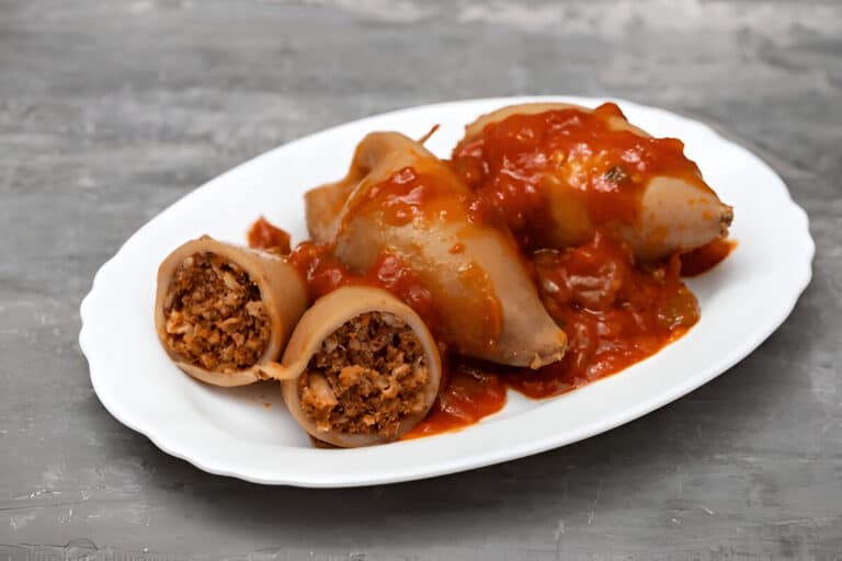 Encornets crus farcis, disposés dans une assiette blanche.